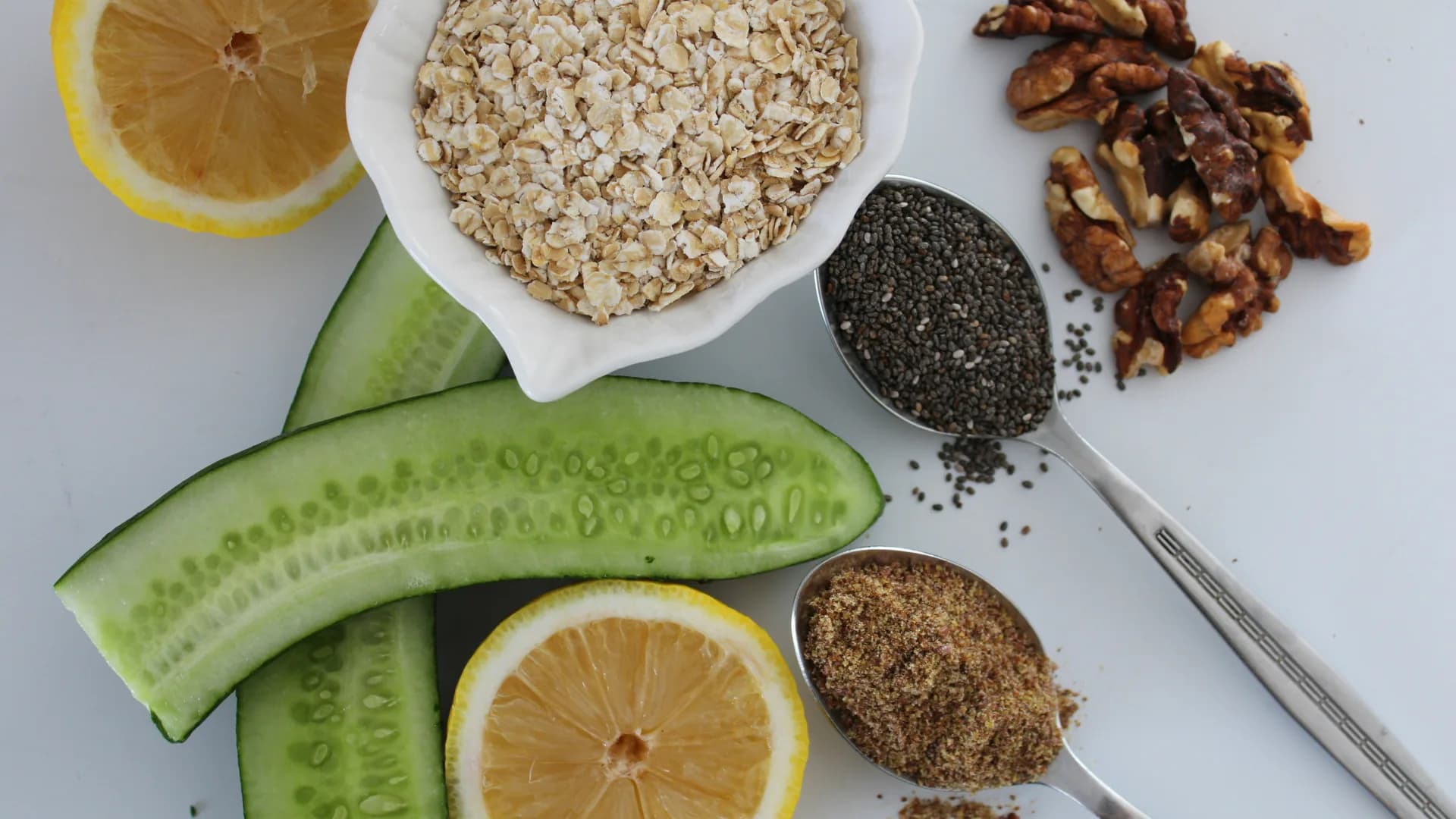 Gezonde orthomoleculaire ingrediënten zoals havermout, komkommer, citroen, chiazaad, lijnzaad en walnoten — rijk aan vezels, omega-3 en antioxidanten voor een gebalanceerd dieet.